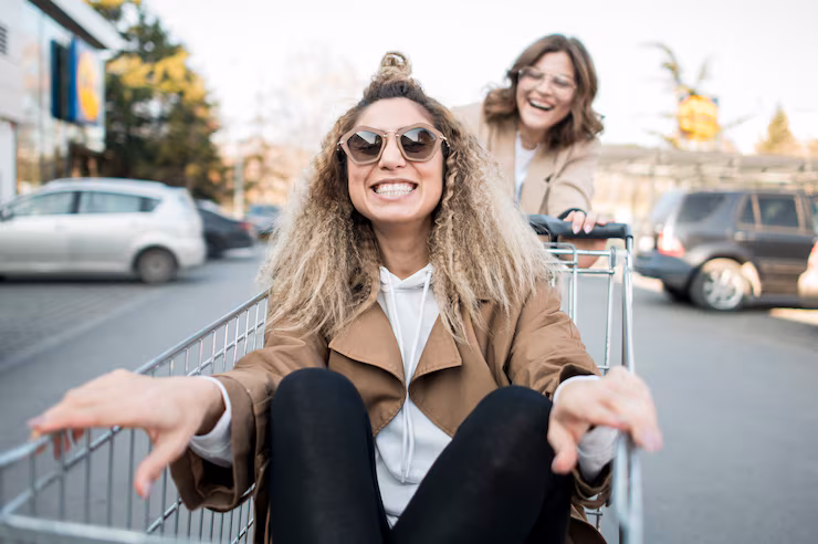 young-women-playing-with-shopping-cart_23-2148495447
